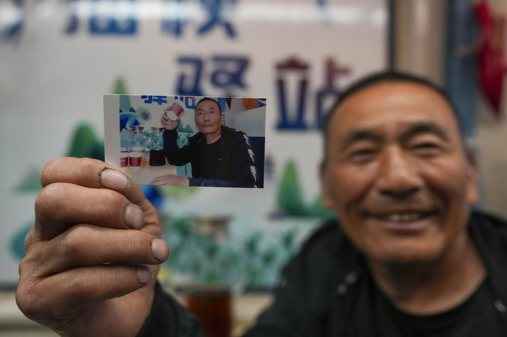 5月13日,乘客在K5153次“插秧专列”上展示列车员为自己拍摄的照片。