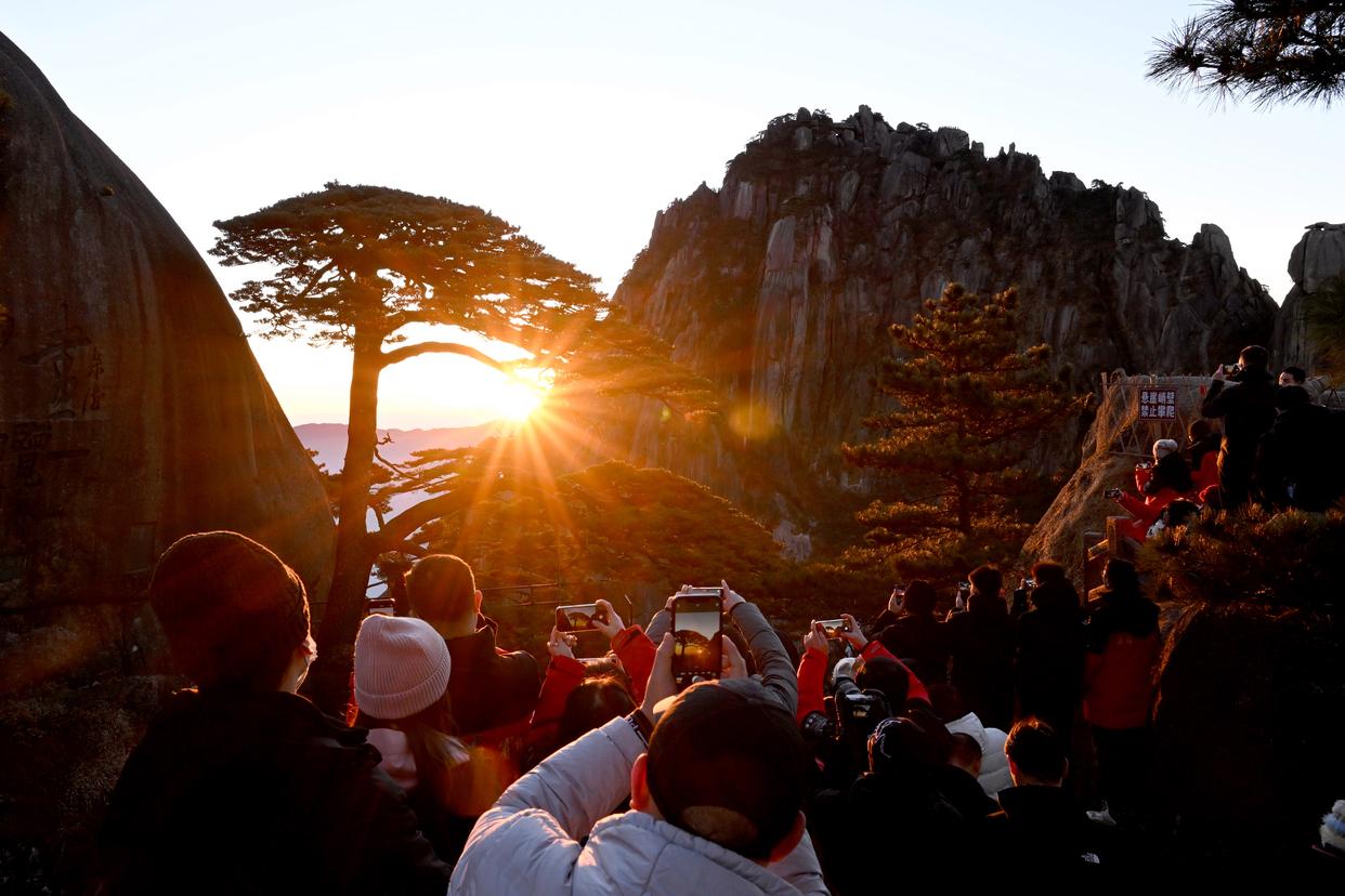 2025年1月1日，游客在安徽黄山风景区迎客松景点观赏日出。新华社记者 黄博涵 摄