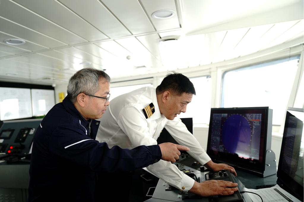 4月20日,“同济”号南海春季航次首席科学家田军教授(左)和“同济”号船长石斌(右)商量考察站位工作。新华社记者张建松 摄